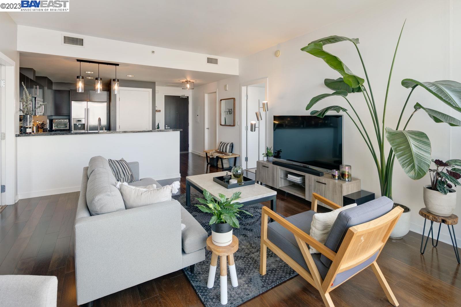 222 Broadway, Unit 1004 Oakland, CA 94607 - Photo 17 of 60 a living room with furniture a flat screen tv and a potted plant