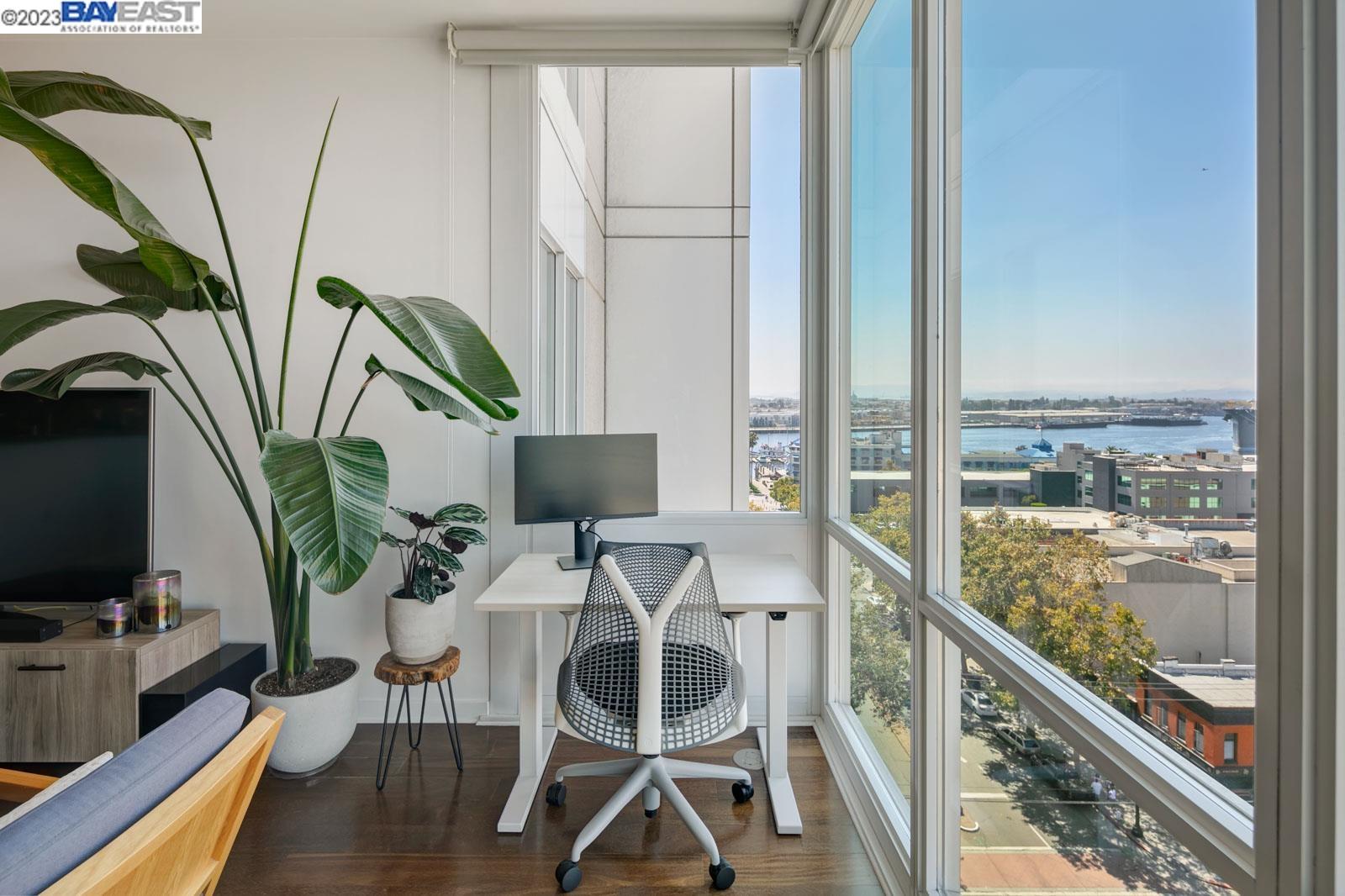222 Broadway, Unit 1004 Oakland, CA 94607 - Photo 18 of 60 a dining room with furniture a potted plant and a floor to ceiling window
