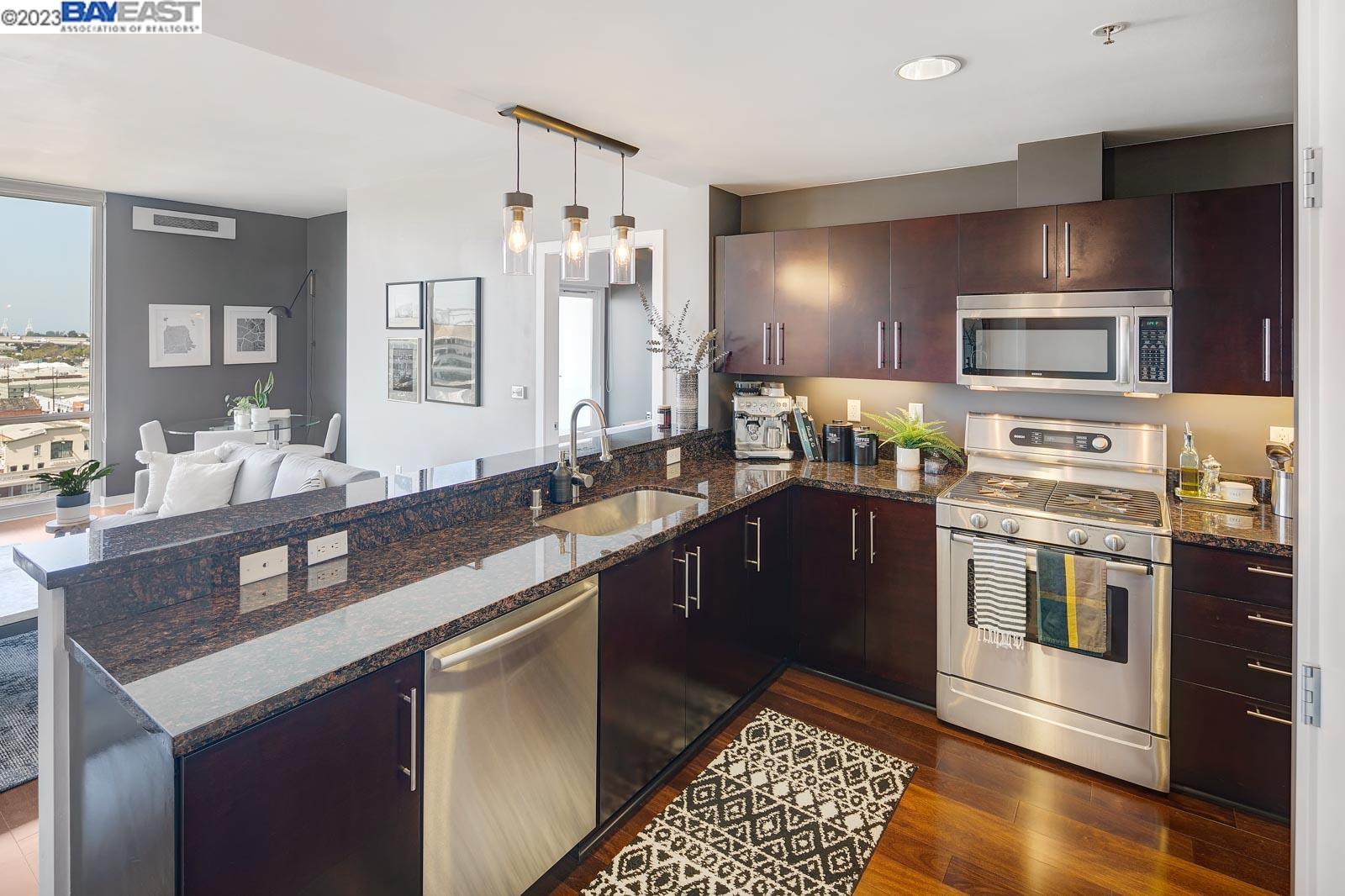 222 Broadway, Unit 1004 Oakland, CA 94607 - Photo 2 of 60 a kitchen with stainless steel appliances granite countertop a sink and stove