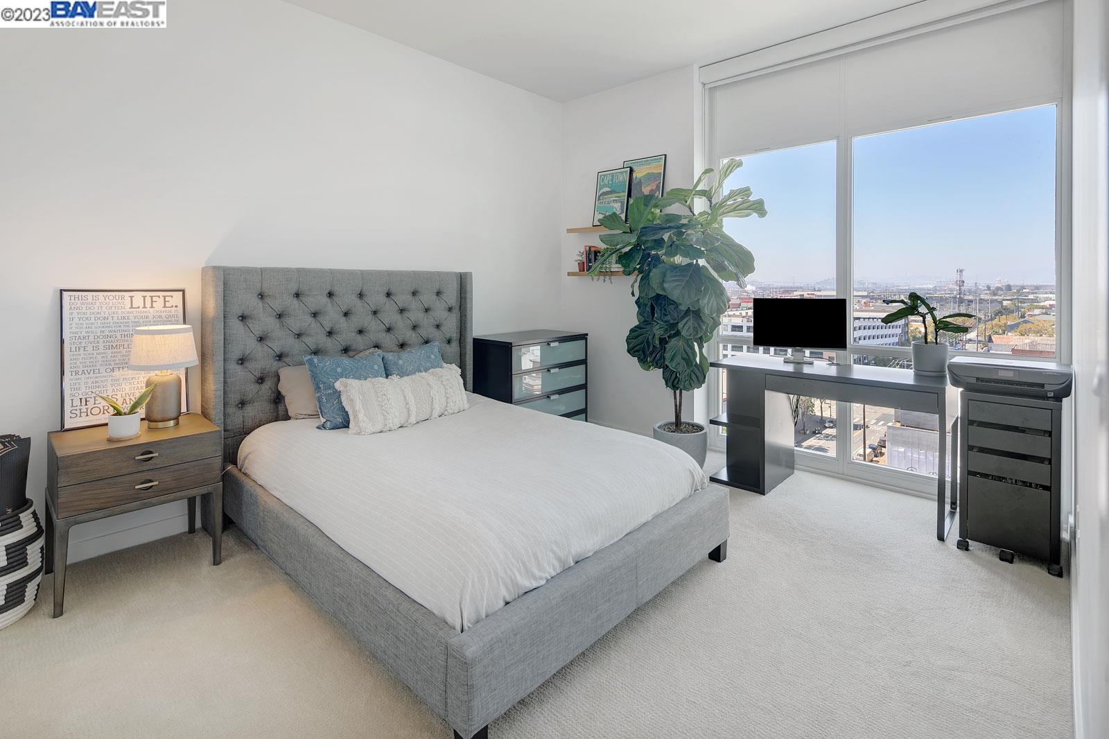 222 Broadway, Unit 1004 Oakland, CA 94607 - Photo 22 of 60 a bedroom with a bed table chair and flat screen tv