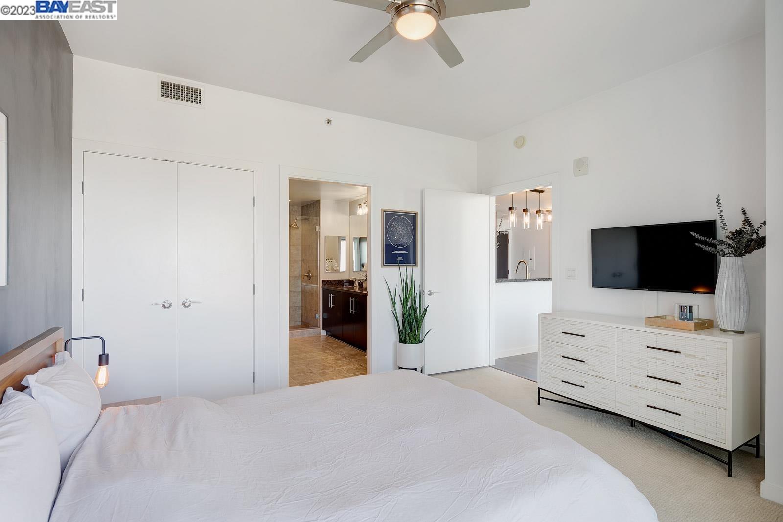 222 Broadway, Unit 1004 Oakland, CA 94607 - Photo 25 of 60 a bedroom with a bed and flat screen tv