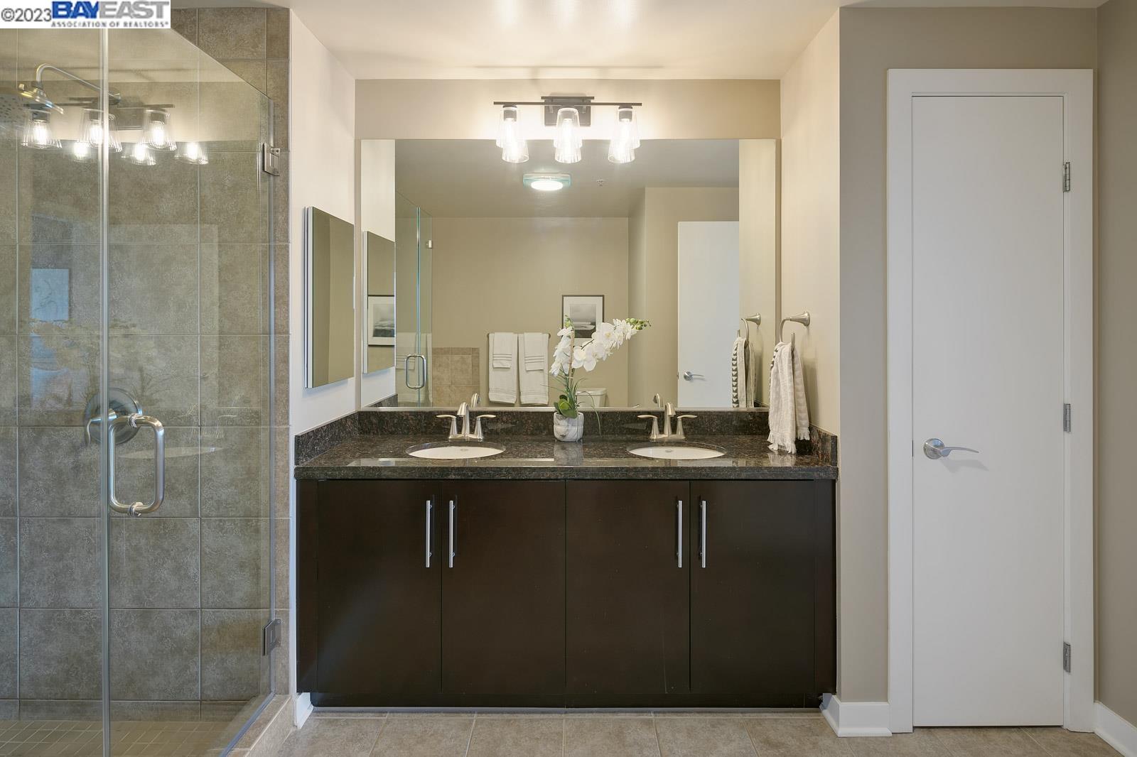 222 Broadway, Unit 1004 Oakland, CA 94607 - Photo 28 of 60 a bathroom with a double vanity sink and mirror