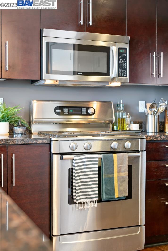 222 Broadway, Unit 1004 Oakland, CA 94607 - Photo 36 of 60 a kitchen with stainless steel appliances granite countertop a stove and a microwave