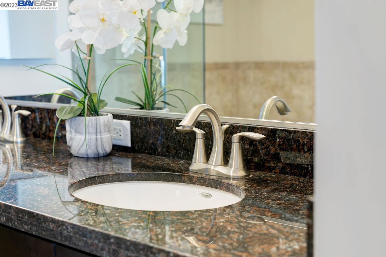 222 Broadway, Unit 1004 Oakland, CA 94607 - Photo 39 of 60 a bathroom with a sink a mirror and vanity