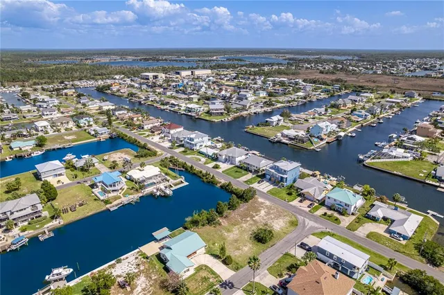 an aerial view of a city with lots of residential buildings ocean and mountain view in back