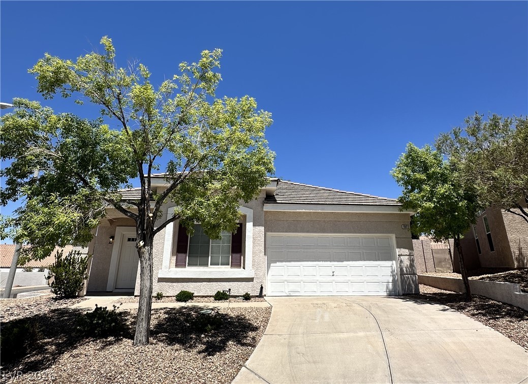 A well-maintained facade with a prominent two-car garage and drought-tolerant landscaping offers immediate curb appeal.