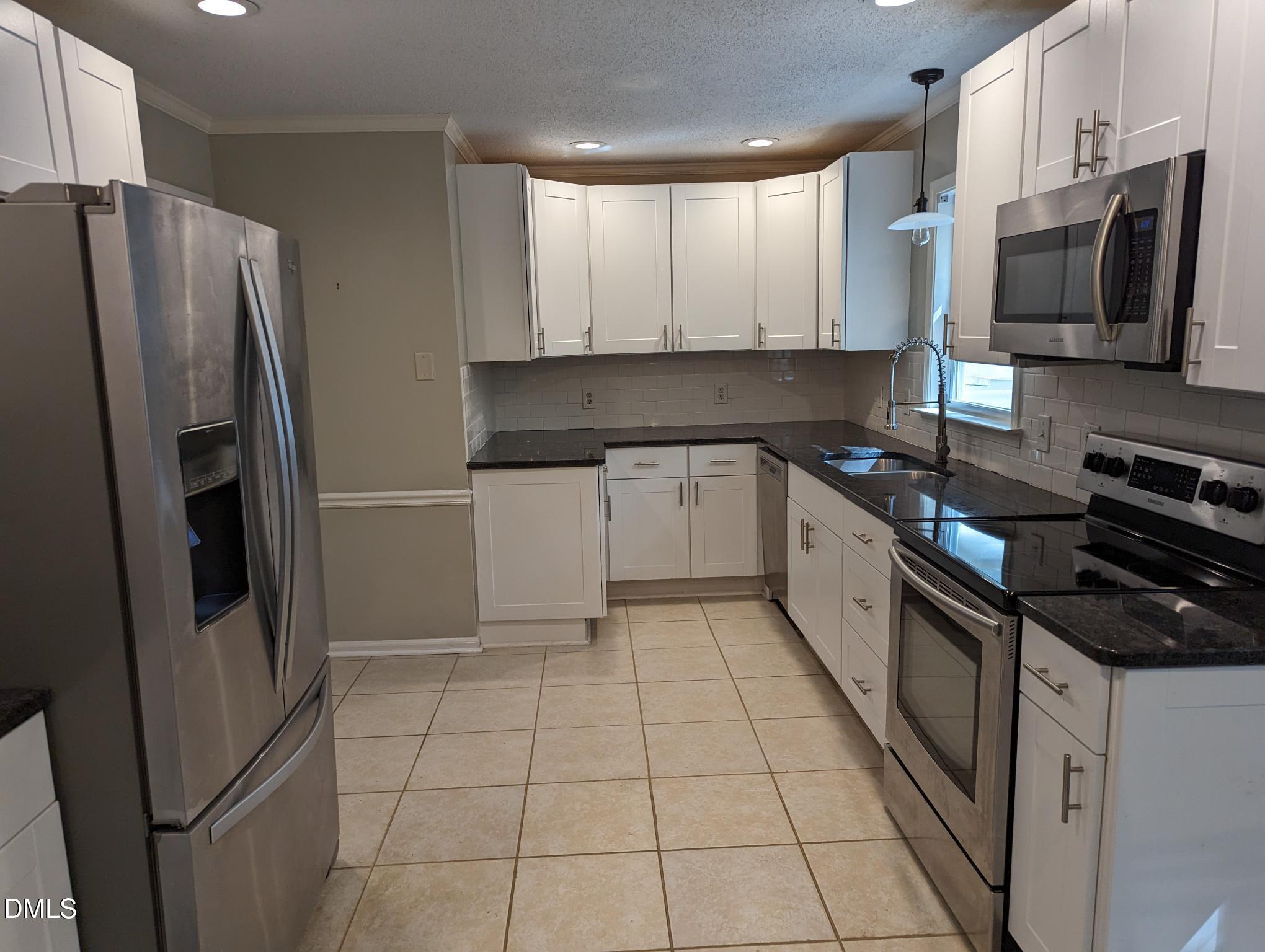 7416 Ray Road Raleigh, NC 27613 - Photo 5 of 12 a kitchen with stainless steel appliances granite countertop a refrigerator stove and sink
