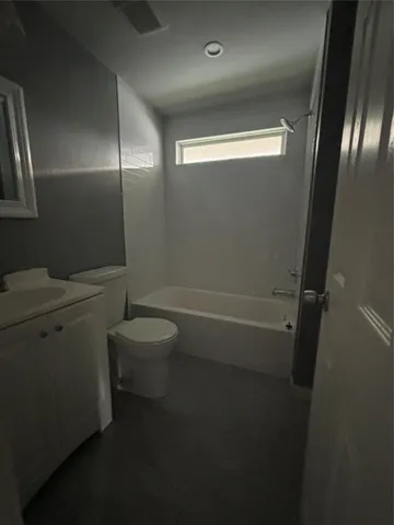a bathroom with a granite countertop toilet and a shower