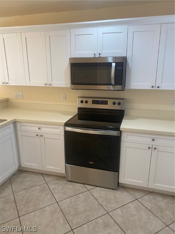 18620 Sebring Road Fort Myers, FL 33967 - Photo 9 of 32 a kitchen with white cabinets and appliances