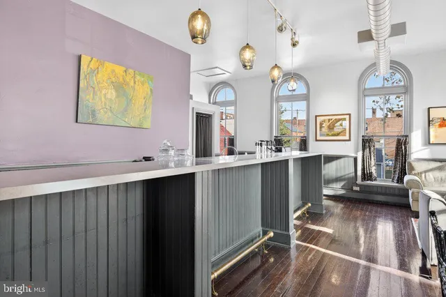 a kitchen with stainless steel appliances granite countertop a stove a sink and a dining table with wooden floor