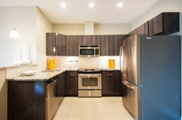 a kitchen with stainless steel appliances granite countertop a stove a refrigerator and a sink