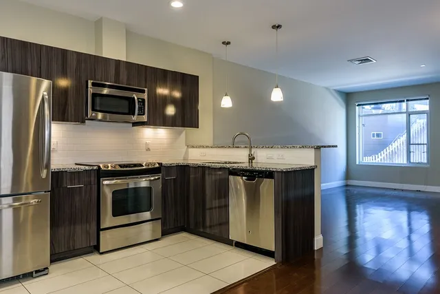 a kitchen with stainless steel appliances granite countertop a stove a microwave and a refrigerator