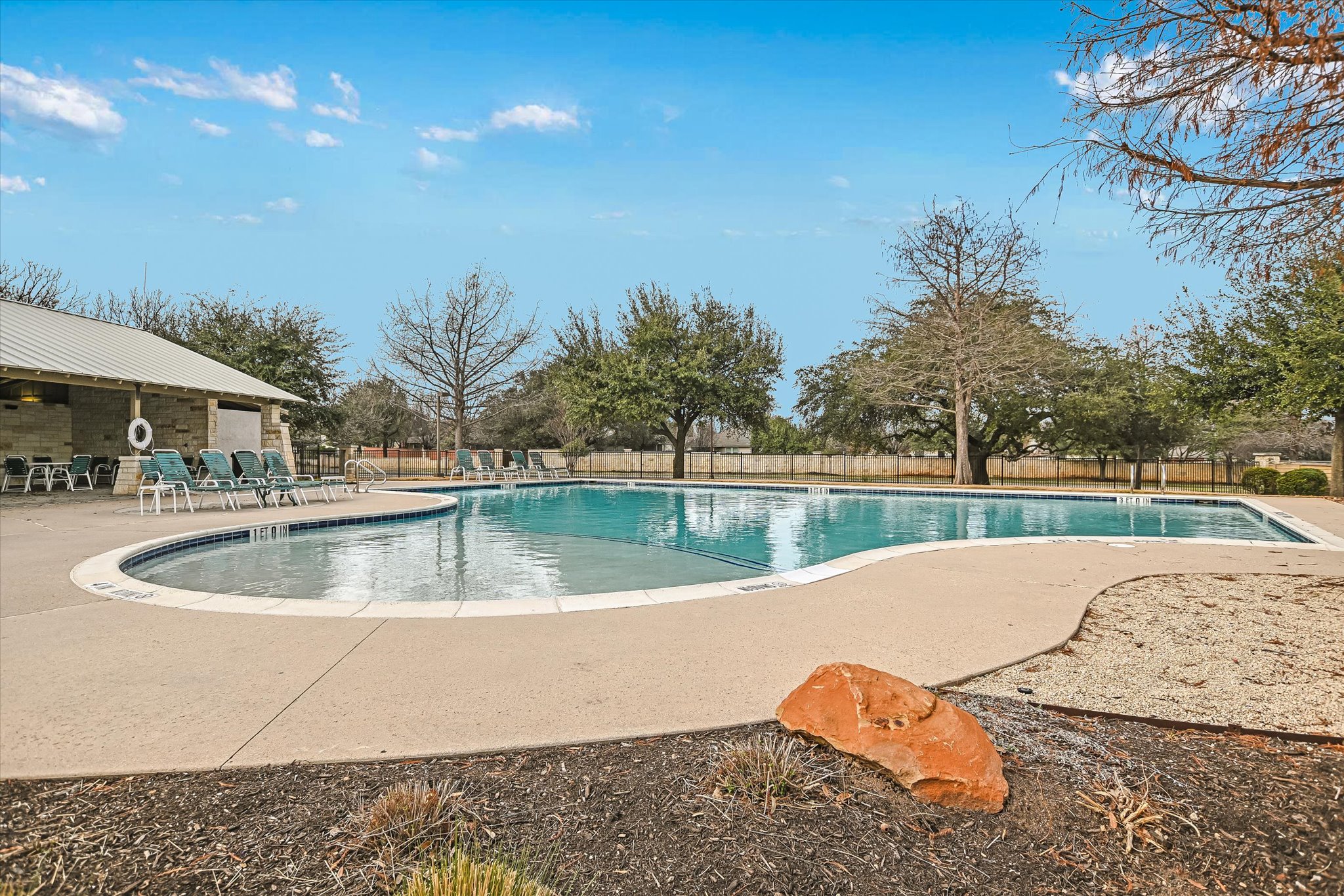 14001 Avery Ranch Boulevard, Unit 202 Austin, TX 78717 - Photo 26 of 30 Expansive community pool with a contoured concrete deck and a stone-clad cabana building featuring a metal roof