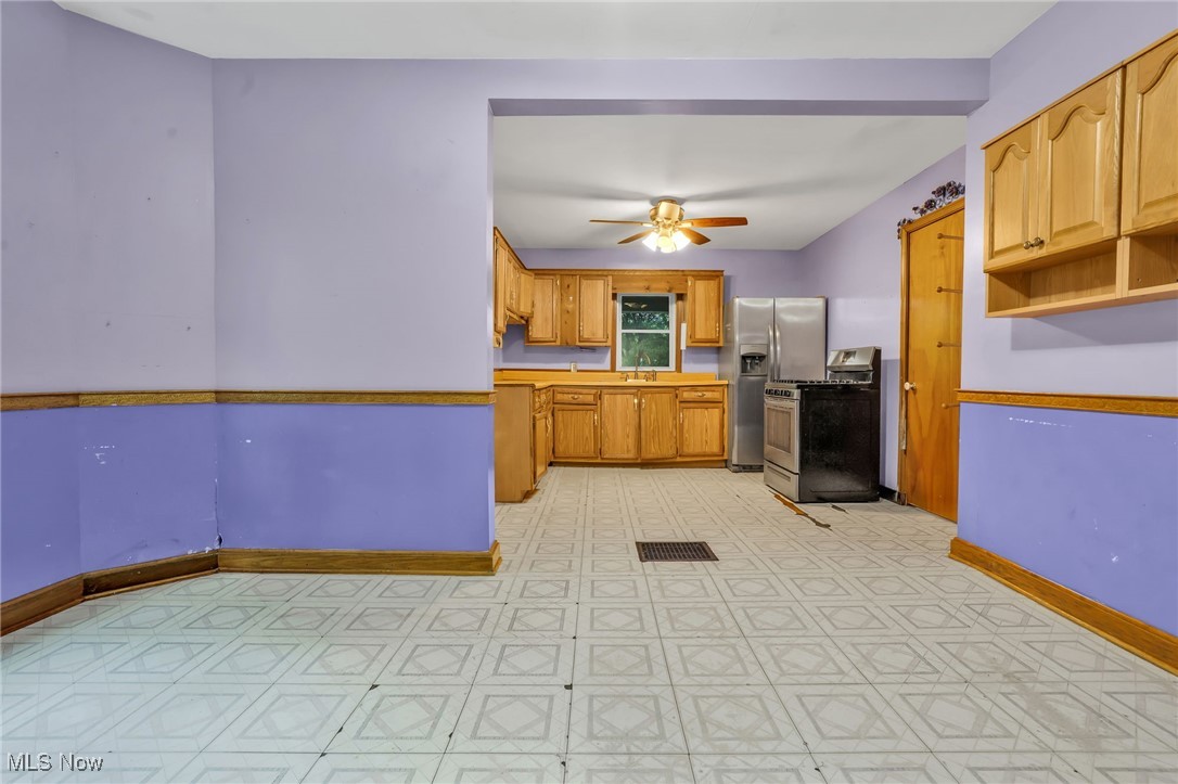 1901 Kimball Road Southeast Canton, OH 44707 - Photo 8 of 32 Kitchen with stove, a sink, baseboards, a ceiling fan, and light countertops