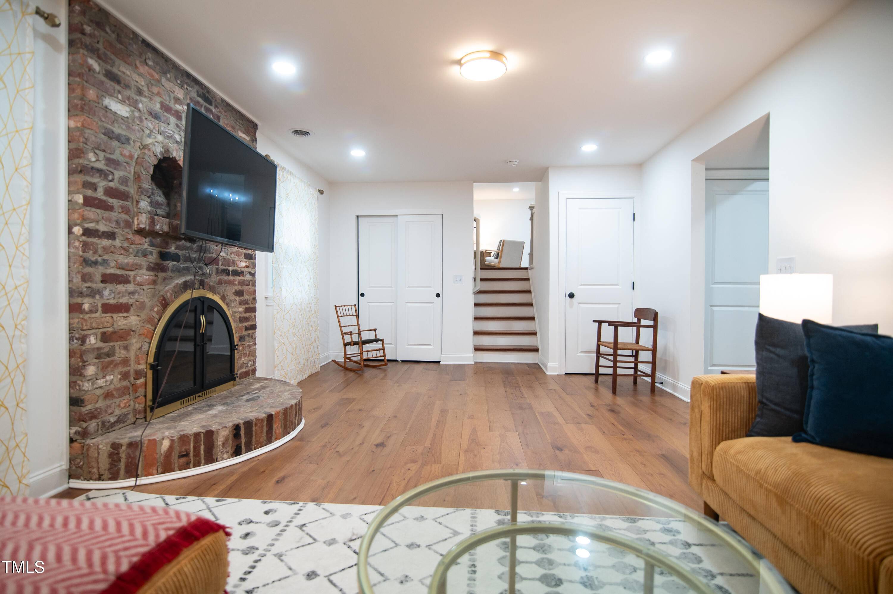 5012 Skidmore Street Raleigh, NC 27609 - Photo 11 of 27 a living room with furniture a flat screen tv and a fireplace