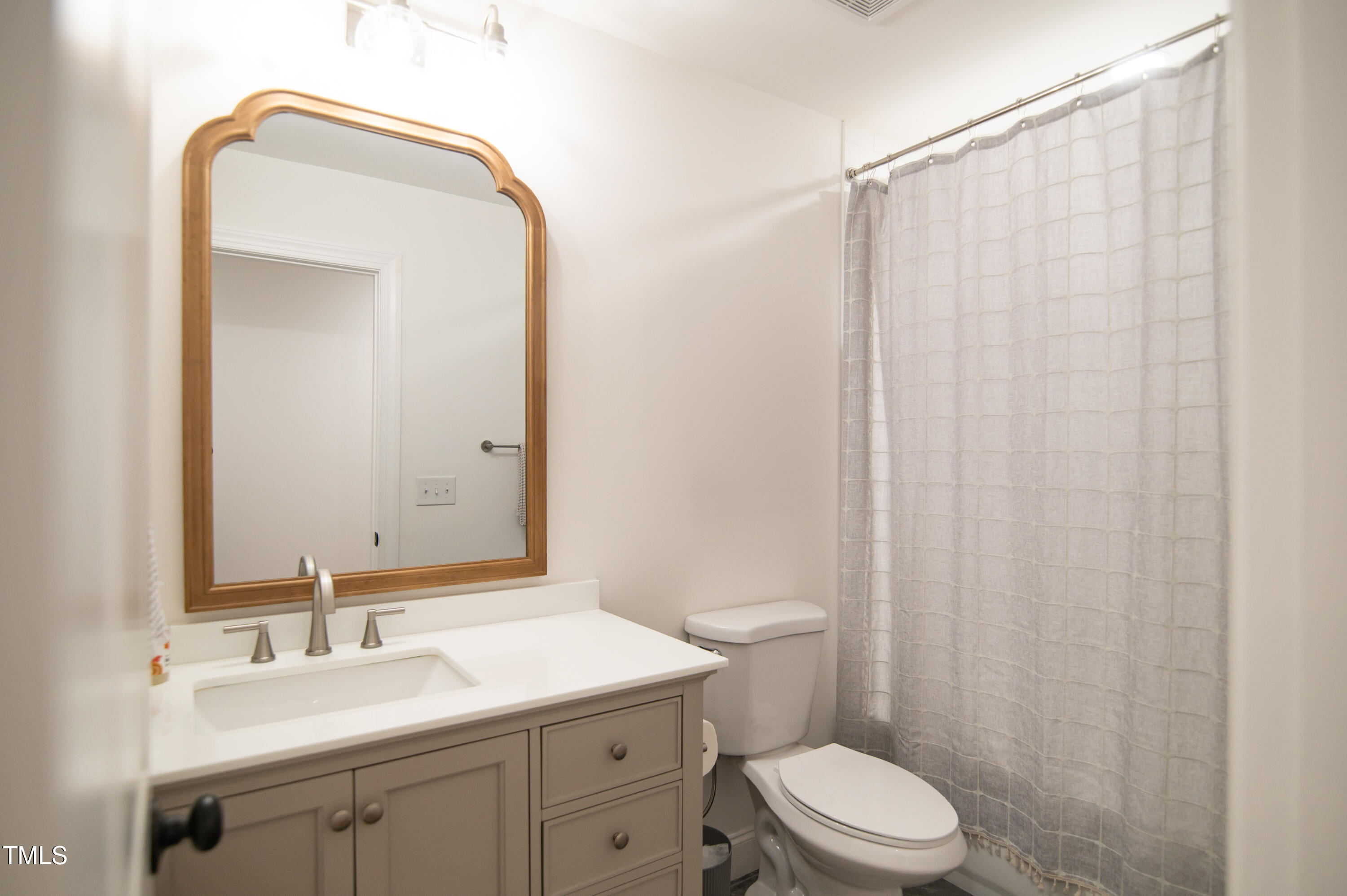 5012 Skidmore Street Raleigh, NC 27609 - Photo 21 of 27 a bathroom with a toilet a sink and a mirror