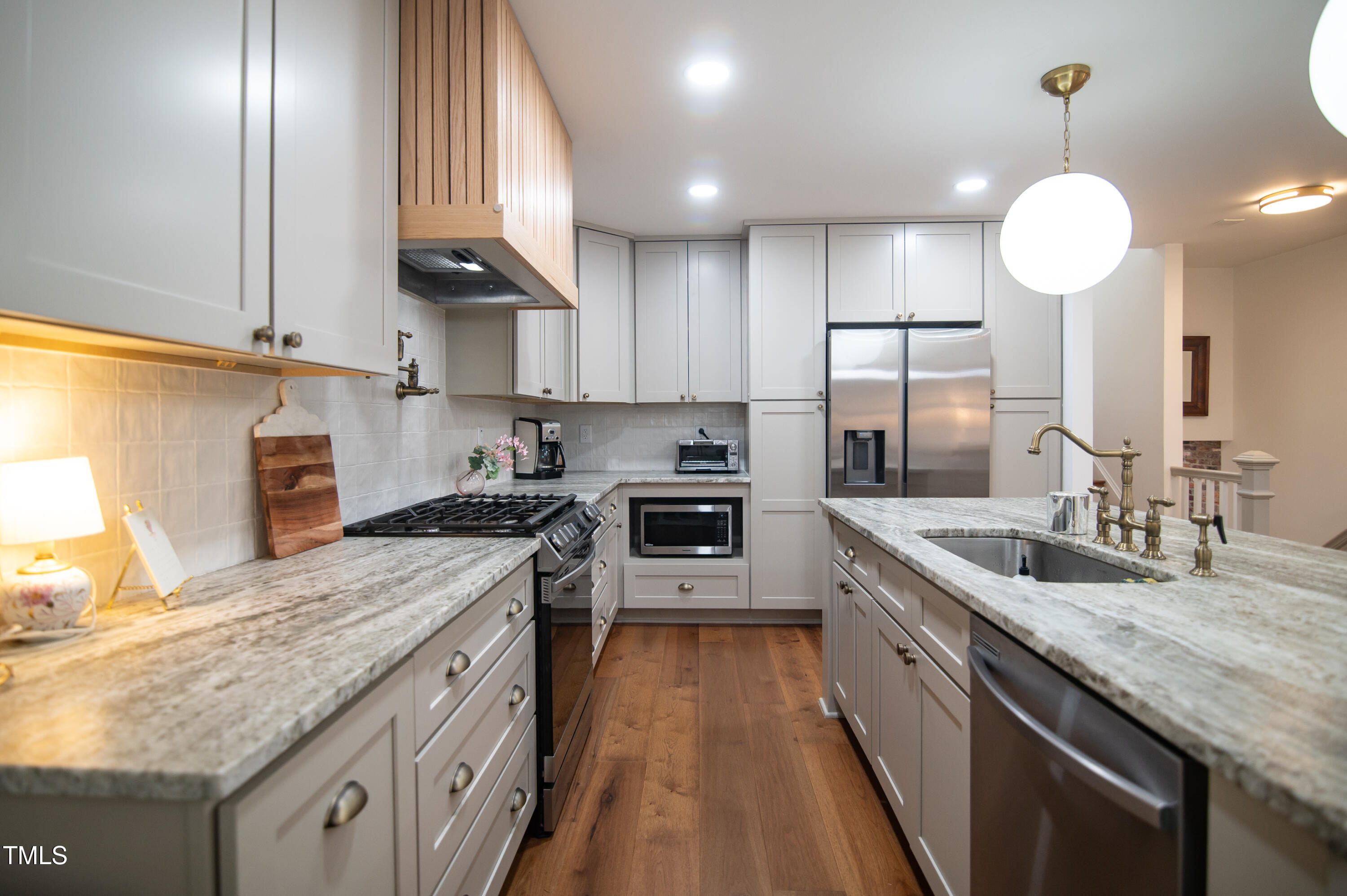 5012 Skidmore Street Raleigh, NC 27609 - Photo 6 of 27 a kitchen with stainless steel appliances granite countertop a sink a stove and a wooden floors