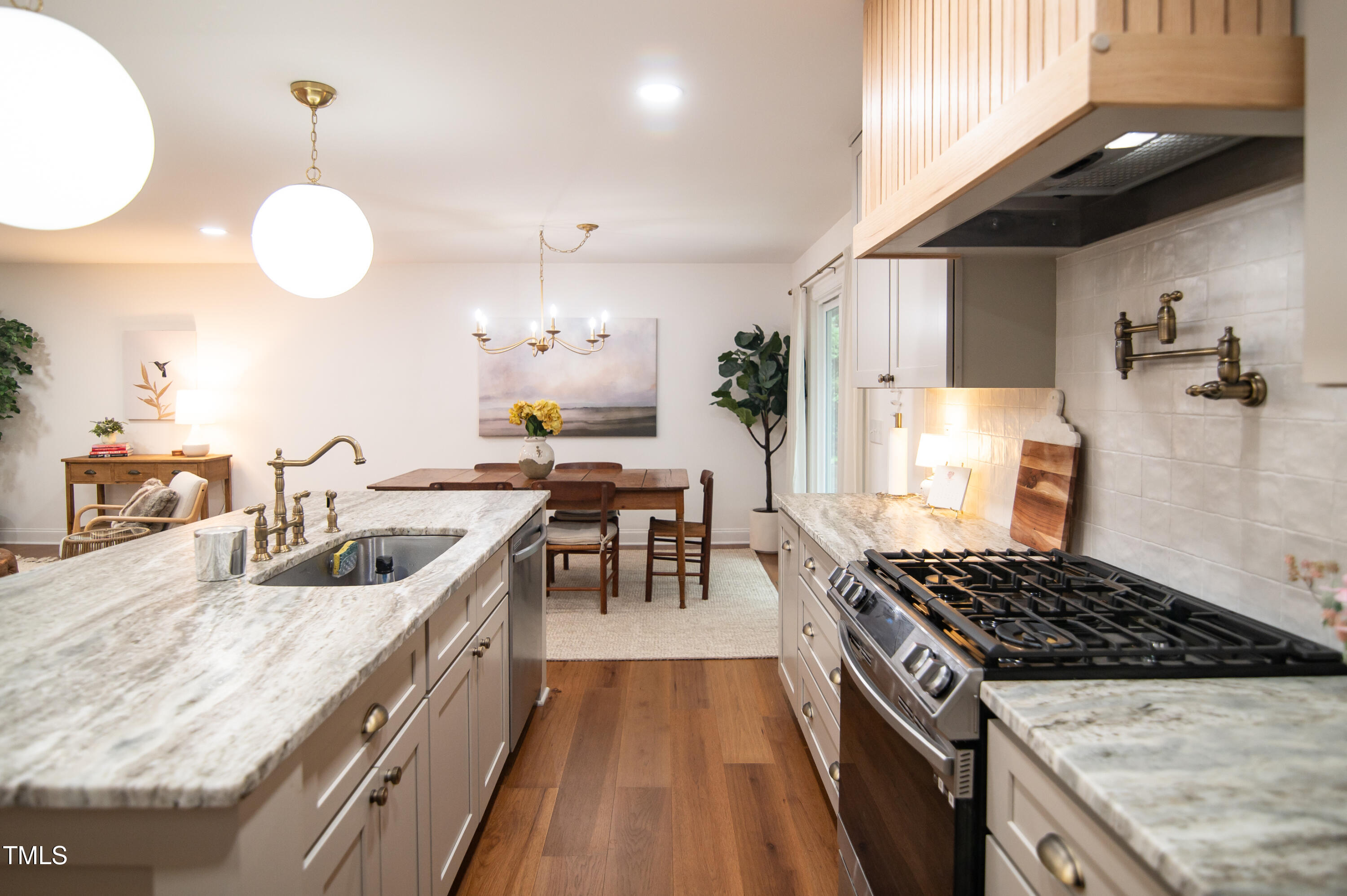 5012 Skidmore Street Raleigh, NC 27609 - Photo 7 of 27 a kitchen with granite countertop a stove and a sink