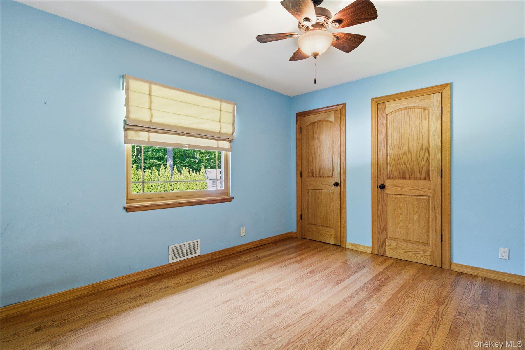 42 Cliff Road Port Jefferson, NY 11777 - Photo 15 of 22 a view of an empty room with window and wooden floor