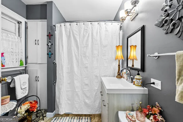 a bathroom with a sink mirror and shower curtain