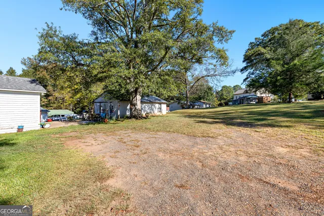 a view of a house with a yard and basketball court