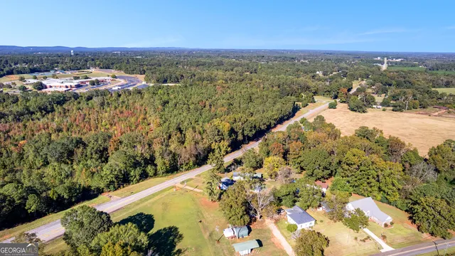 an aerial view of a house with swimming pool and large trees