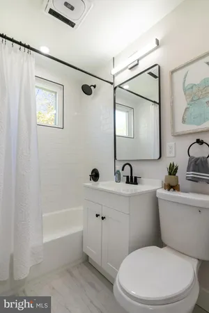 a white toilet sitting next to a bathroom sink and tub