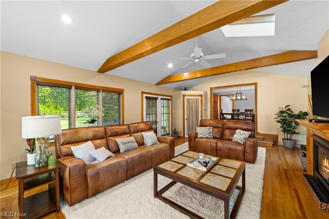 482 Trebisky Road Cleveland, OH 44143 - Photo 4 of 35 Living room with ceiling fan with notable chandelier, vaulted ceiling with skylight, and wood-type flooring