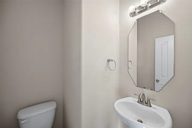 a bathroom with a toilet a sink and mirror