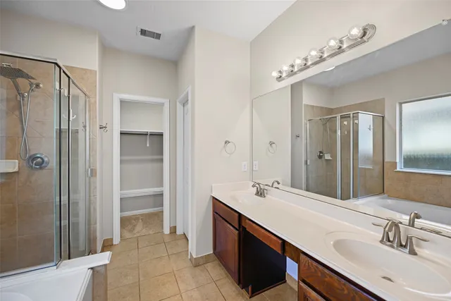 a spacious bathroom with a double vanity sink mirror and shower