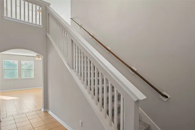a view of staircase with wooden floor and white walls