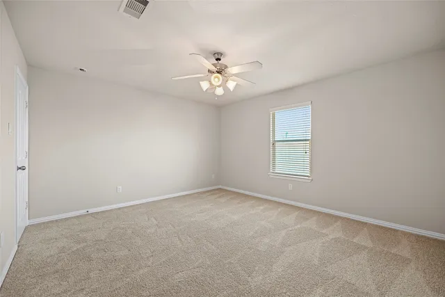 an empty room with a window and a fan