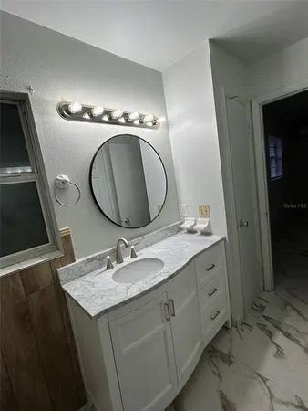 a bathroom with a granite countertop double vanity sink and a mirror