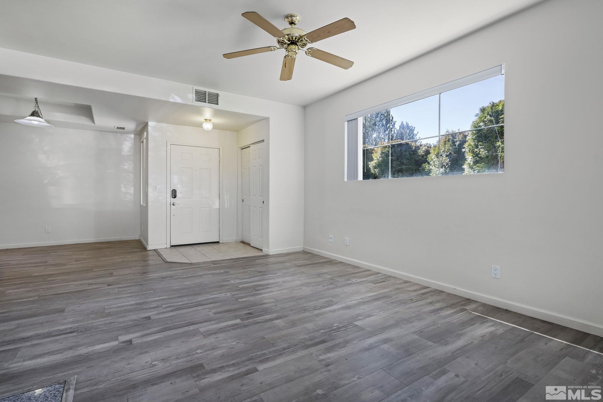 900 S Meadows, Unit 2911 Reno, NV 89521 - Photo 6 of 27 an empty room with wooden floor and windows
