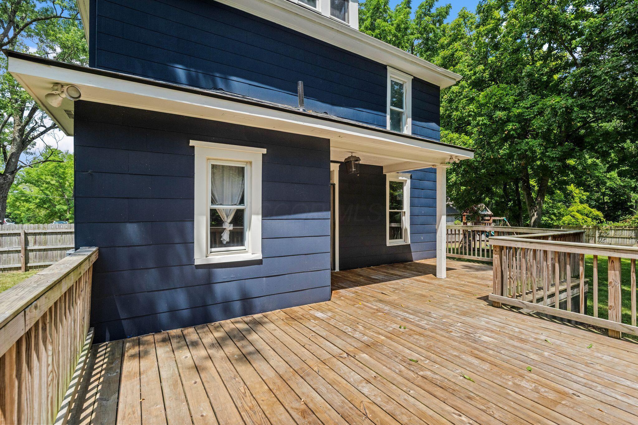 107 Price Road Columbus, OH 43230 - Photo 33 of 51 Expansive wood deck with natural wood railing, dark blue siding, white window trim, and a covered entry