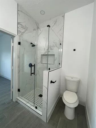 a bathroom with a toilet and a shower