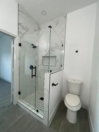 a bathroom with a toilet and a shower