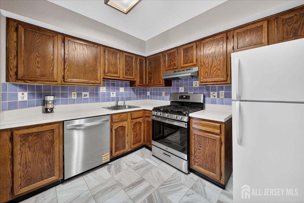 306 Trinity Court, Unit 12 Princeton, NJ 08540 - Photo 6 of 26 a kitchen with stainless steel appliances granite countertop a stove a sink and a refrigerator