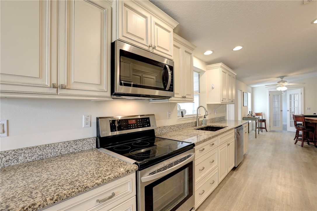 362 Egret Circle Barefoot Bay, FL 32976 - Photo 12 of 36 a kitchen with stainless steel appliances granite countertop a stove a sink and a microwave