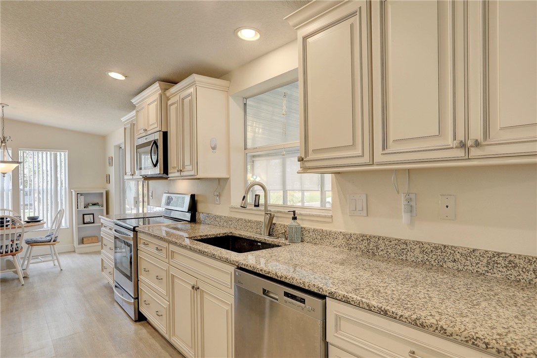 362 Egret Circle Barefoot Bay, FL 32976 - Photo 13 of 36 a kitchen with stainless steel appliances granite countertop a sink a stove and cabinets