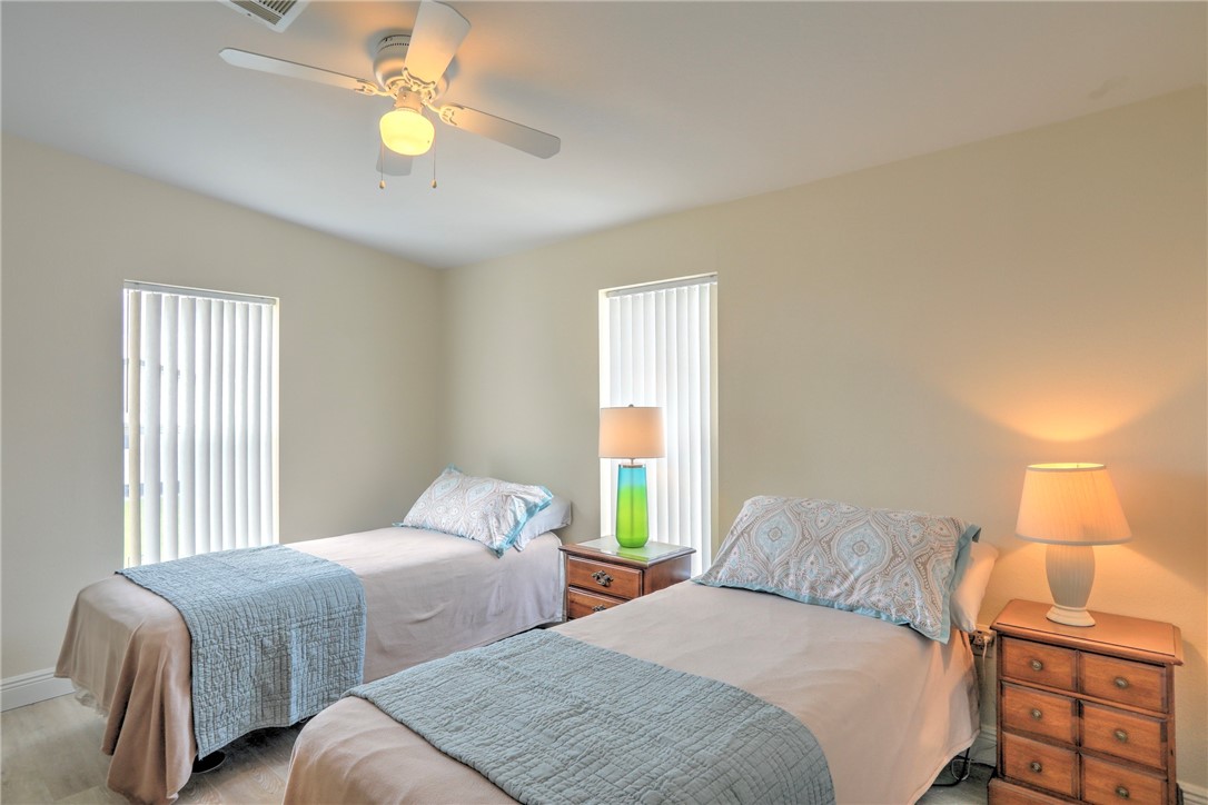 362 Egret Circle Barefoot Bay, FL 32976 - Photo 19 of 36 a bedroom with two beds and a chandelier