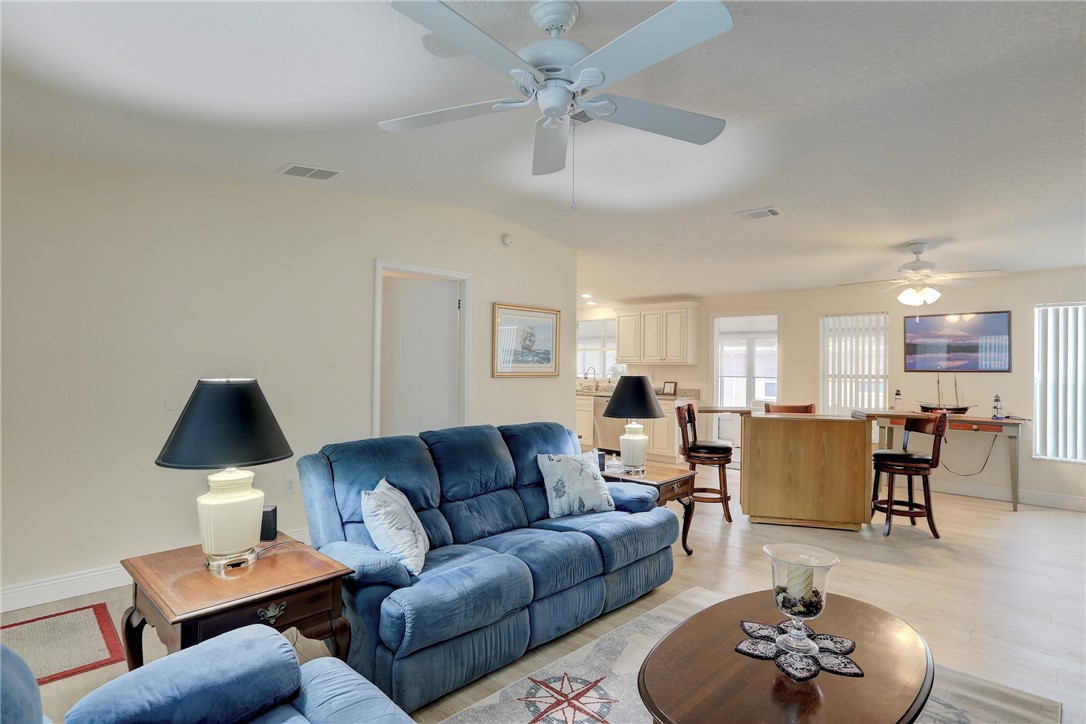 362 Egret Circle Barefoot Bay, FL 32976 - Photo 7 of 36 a living room with furniture a rug and a chandelier