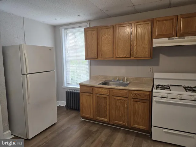 a kitchen with stainless steel appliances granite countertop a refrigerator a sink and a stove