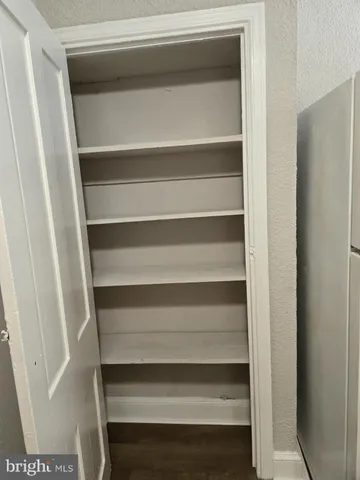 a view of walk in closet with empty racks