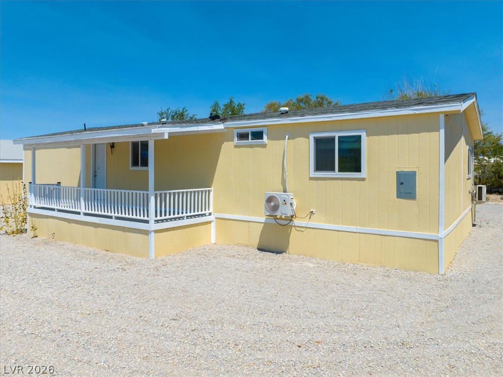 4081 Retread Road Pahrump, NV 89048 - Photo 60 of 98 A quaint yellow residence features a welcoming covered porch, perfect for enjoying sunny afternoons.