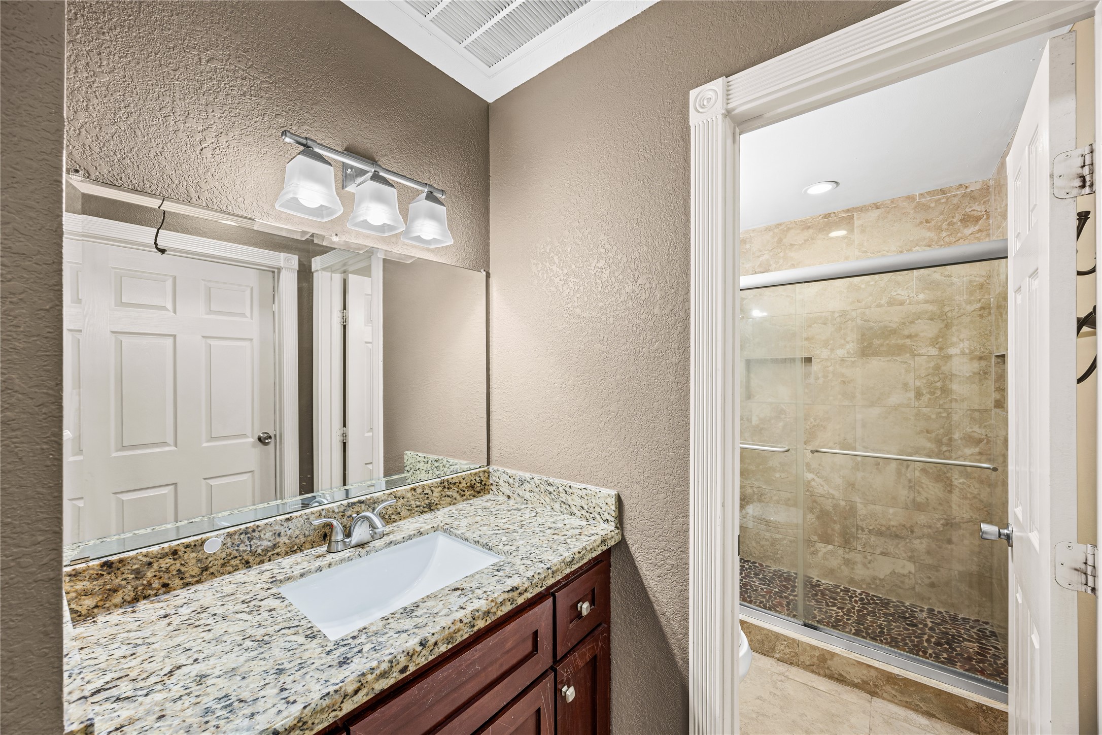 10221 Flaxman Street Houston, TX 77029 - Photo 17 of 20 a bathroom with a granite countertop sink and a mirror
