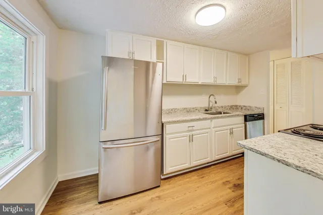 a kitchen with granite countertop cabinets appliances and a window