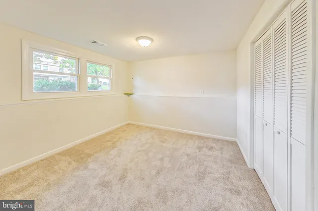 an empty room with windows and closet
