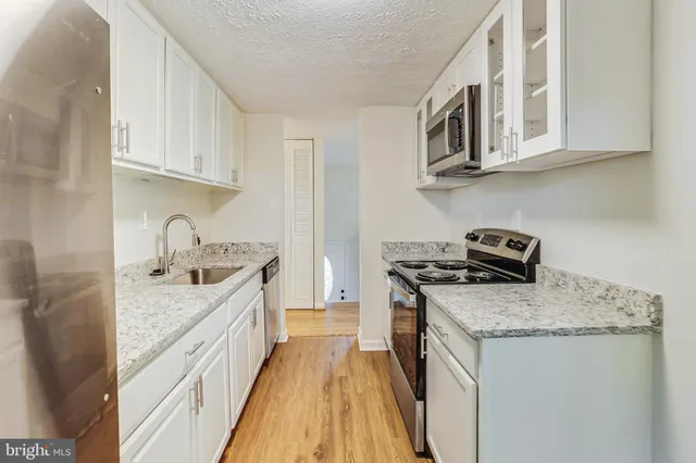 a kitchen with stainless steel appliances granite countertop a sink stove and cabinets