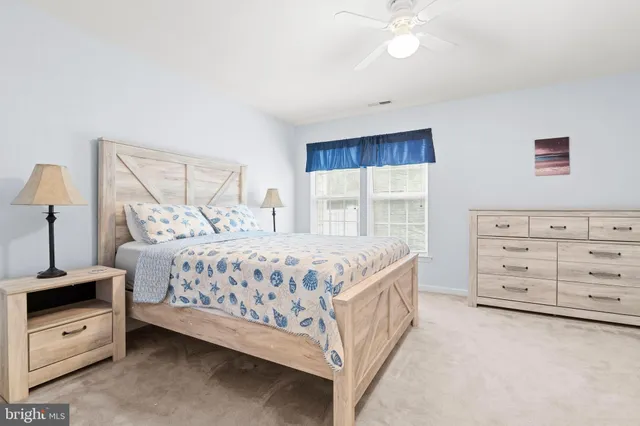 a bedroom with a bed a dresser and a window